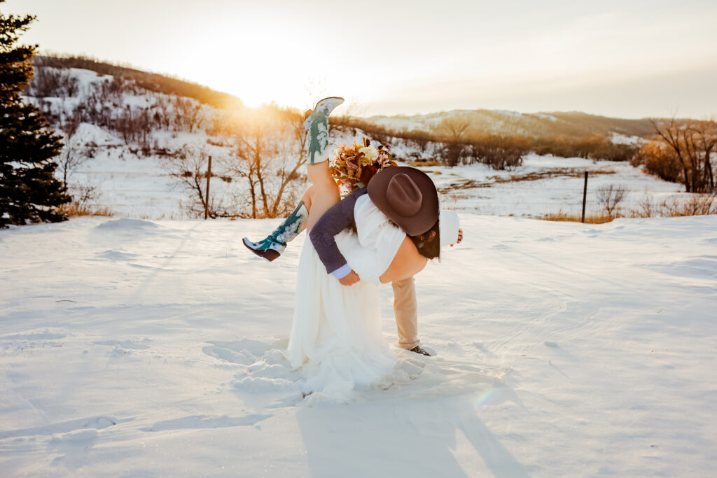 Winter wedding photos of bride and groom kissing in the snow