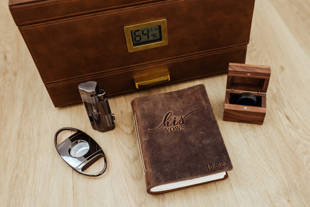 grooms details include vow book ring ring box and cigar cutter